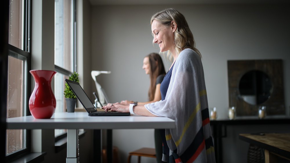 very happy woman in gray tank top using macbook air