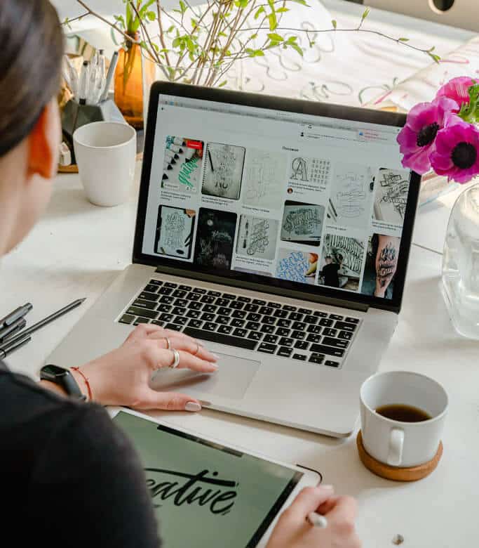 Woman working on laptop with flowers on the desk