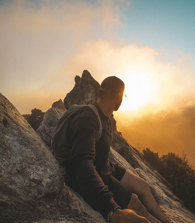 Man sitting in the mountains, representing work-life balance