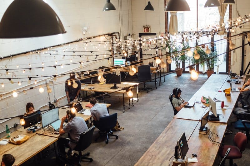 people sitting in front of computer monitors at a coworking space to fend off founder loneliness